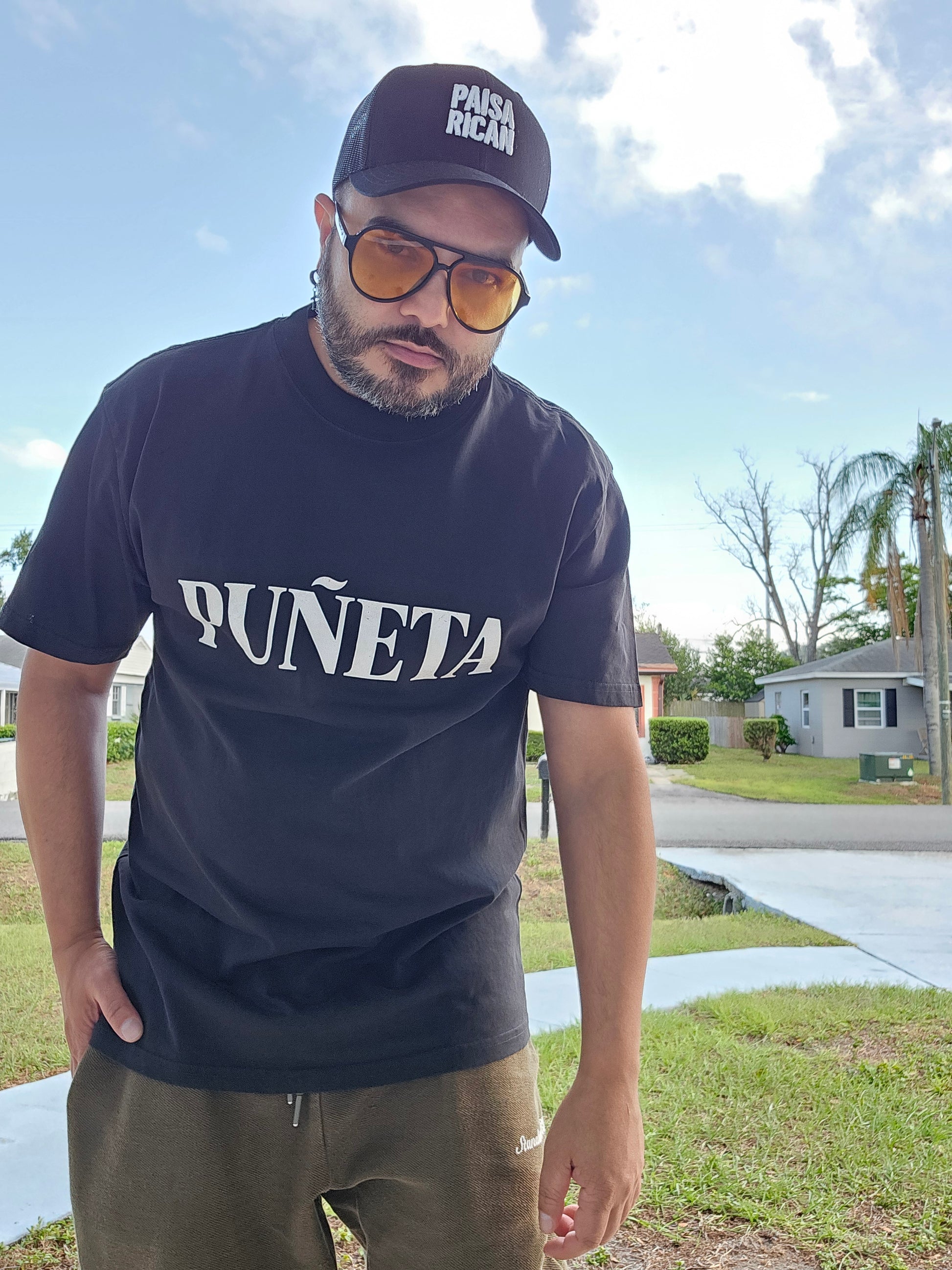 Héctor Santiago, fundador de PaisaRican, usando PUÑETA Oversized Faded Tee charcoal — diáspora paisa-boricua
